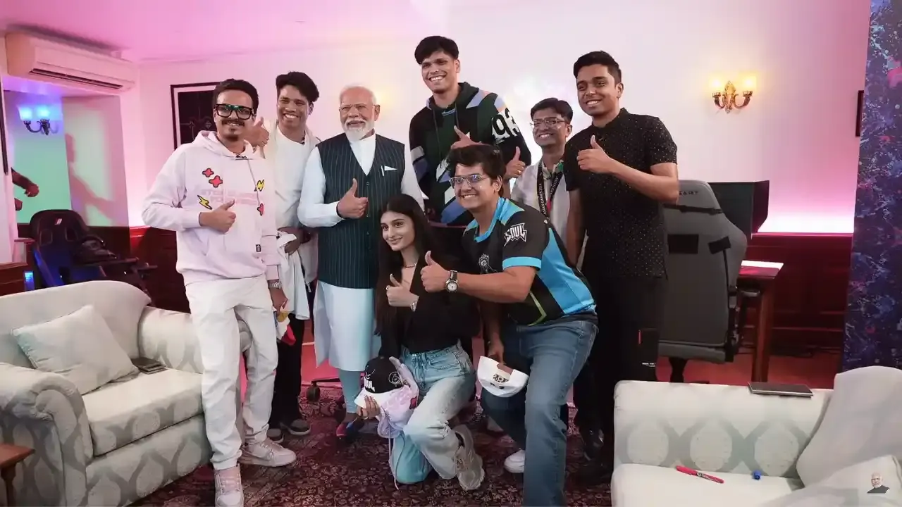 A group of gamers discussing strategies with Prime Minister Modi, showcasing collaboration between government and gaming community.